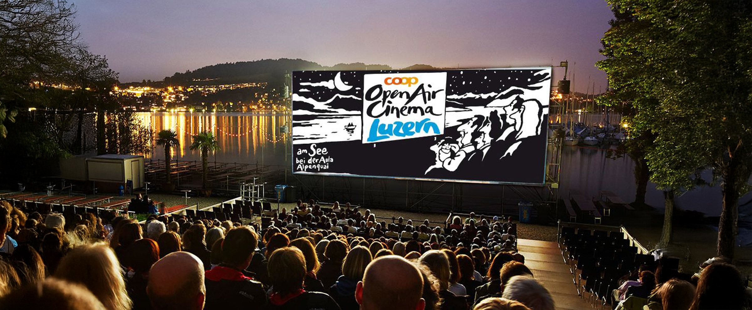 Personen sitzend vor einer Leinwand am See am Alpenquai in Luzern