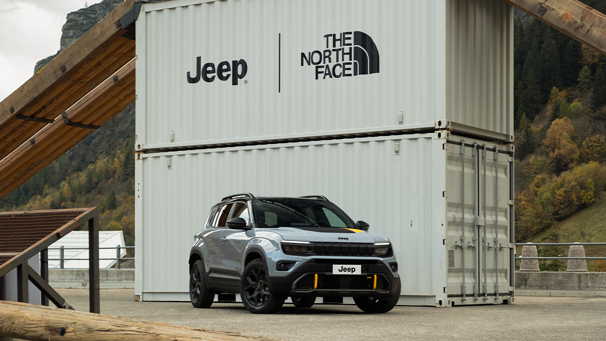 Jeep Avenger - The North Face Edition vor einem Container mit den Logos von Jeep und The North Face